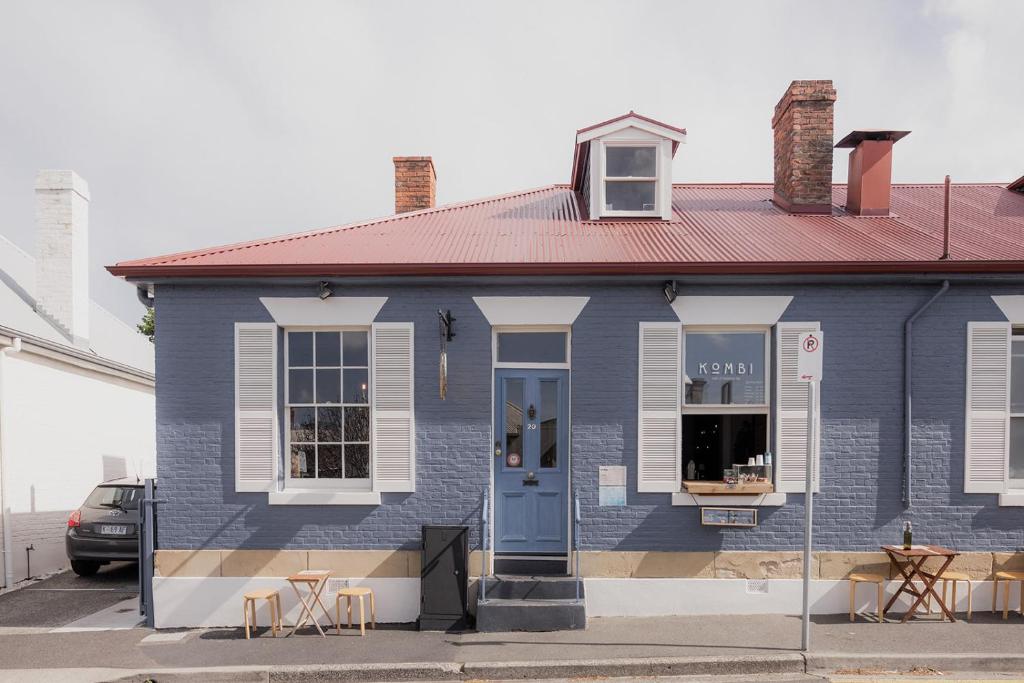 a blue house with a red roof and chairs at 'Fifteen' - Heritage Terrace in Battery Point in Hobart