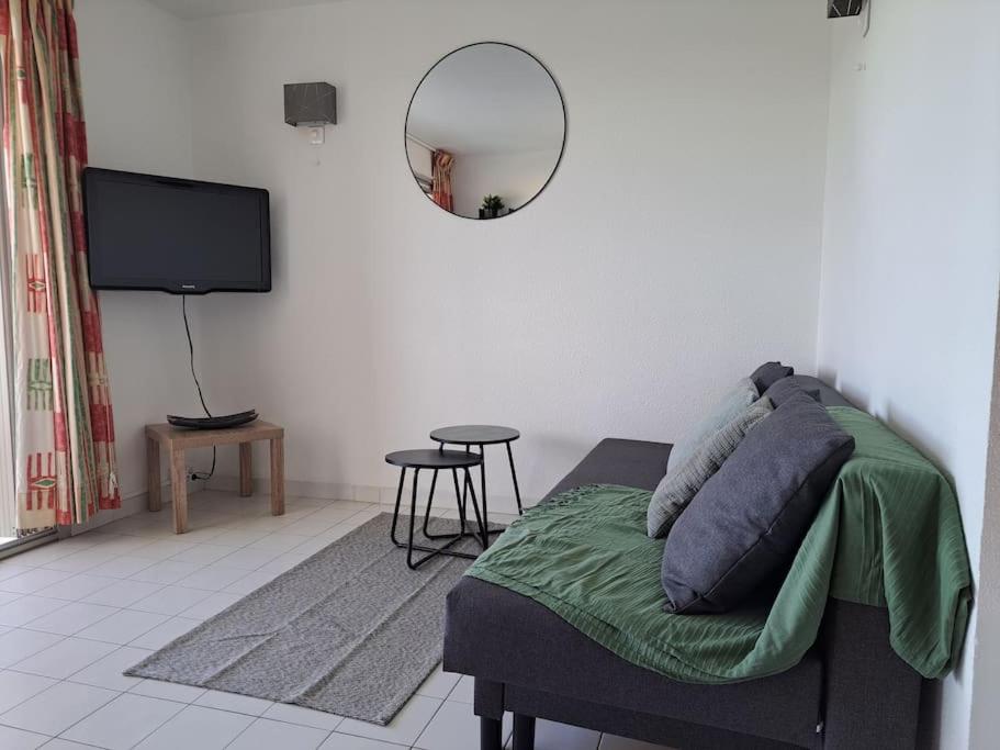 un salon avec un canapé et une télévision à écran plat dans l'établissement Sopraland 514, T2 pour 5 pers, piscine, petite vue mer, au Cap d'Agde