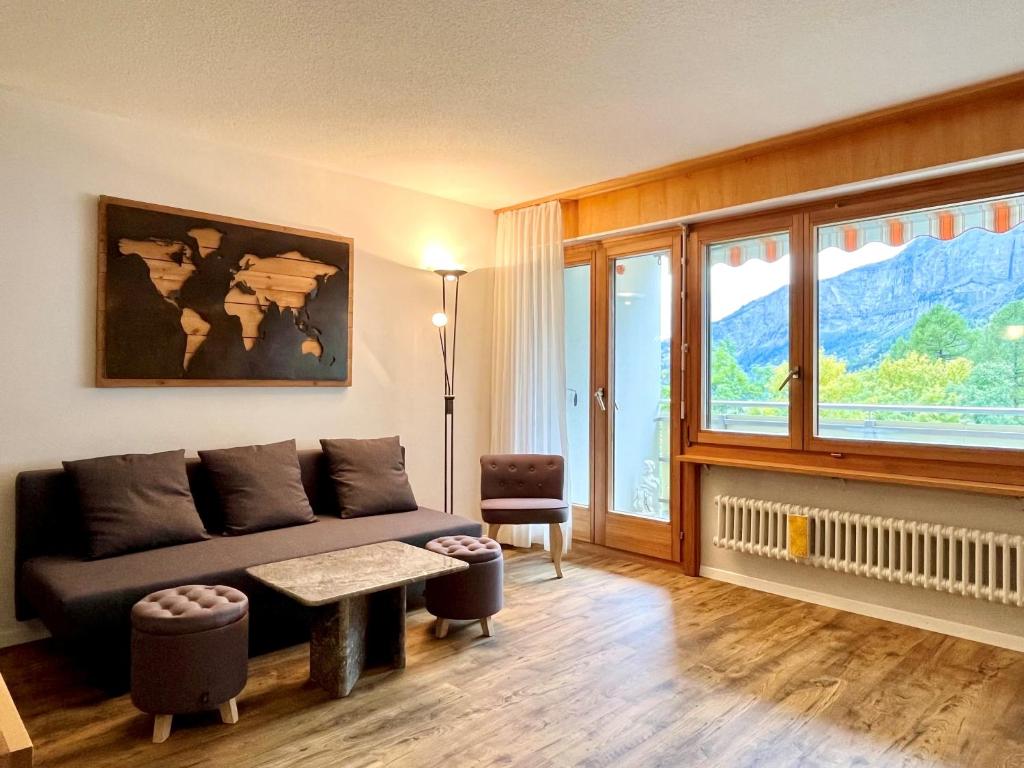 a living room with a couch and a large window at Panorama 20, Grosses Studio, Nahe Ski-Pisten, Parkplatz in Leukerbad