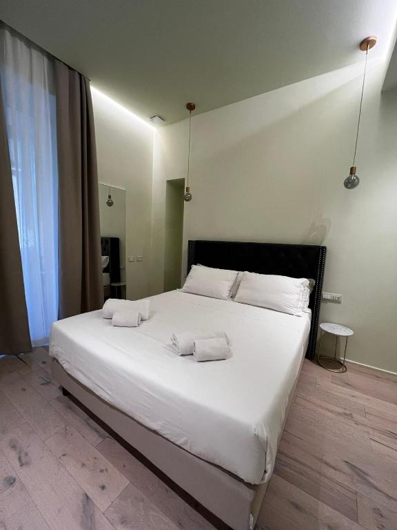 a bedroom with a large white bed with two pillows at Adalesia Hotel & Coffee in Turin