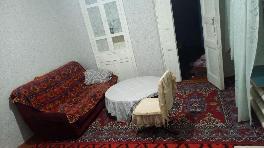 Kleines Zimmer mit einem Bett und einer Tür in der Unterkunft Юнусабад 19 квартл in Taschkent