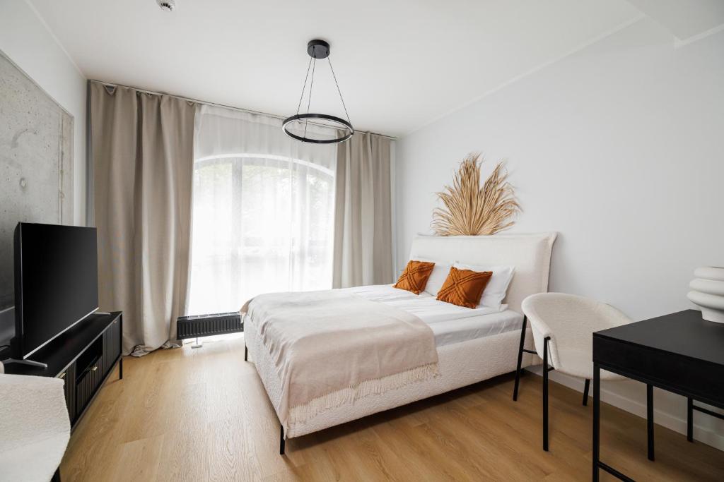 波兹南Aparthotel City Break Plac Wolności 6的一间带床和电视的白色卧室