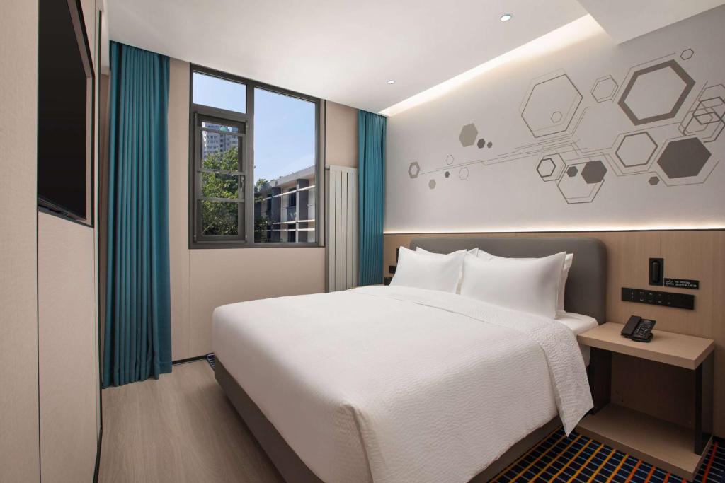 Postel nebo postele na pokoji v ubytování Microtel by Wyndham Xian Beilin