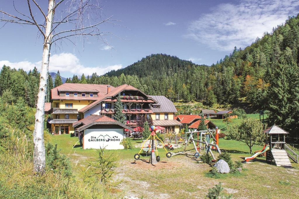 ein großes Gebäude mit einem Spielplatz davor in der Unterkunft Hotel Gailberghöhe in Kötschach