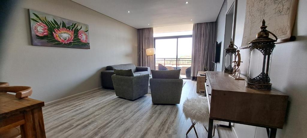 ein Wohnzimmer mit einem Sofa und Stühlen in einem Zimmer in der Unterkunft Zimbali Suites 505 in Ballito
