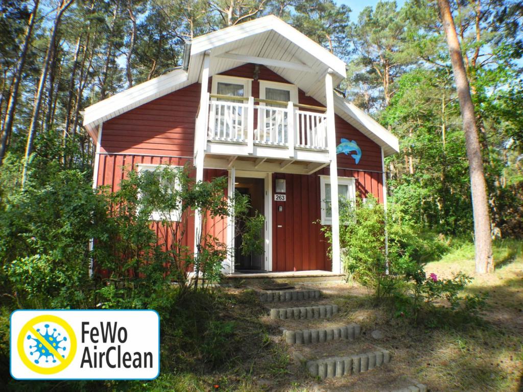 a red house with a porch and stairs leading to it at Hagebutte - Baabe in Baabe