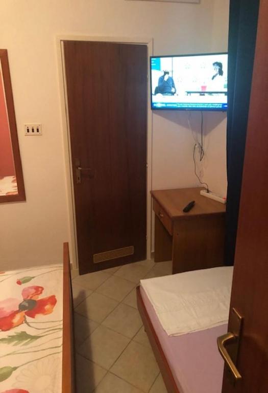 pokój z drzwiami, telewizorem i łóżkiem w obiekcie Apartments Denko w mieście Kali