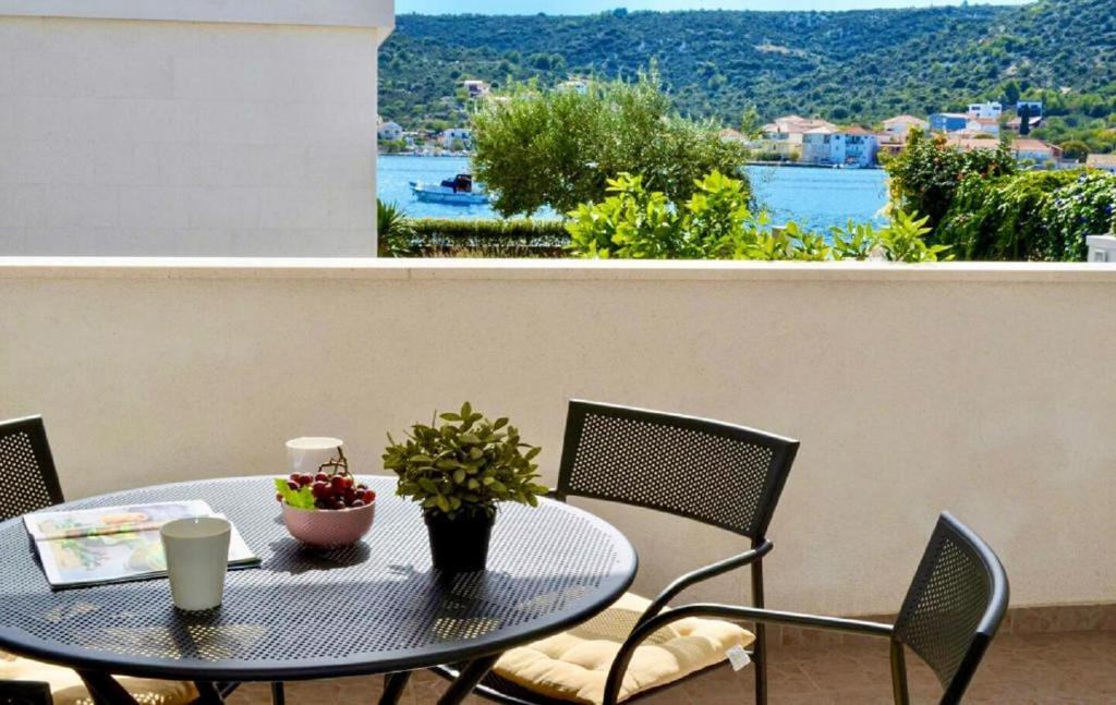 ein Tisch und Stühle auf einem Balkon mit Blick auf das Wasser in der Unterkunft House Pazanin in Vinišće
