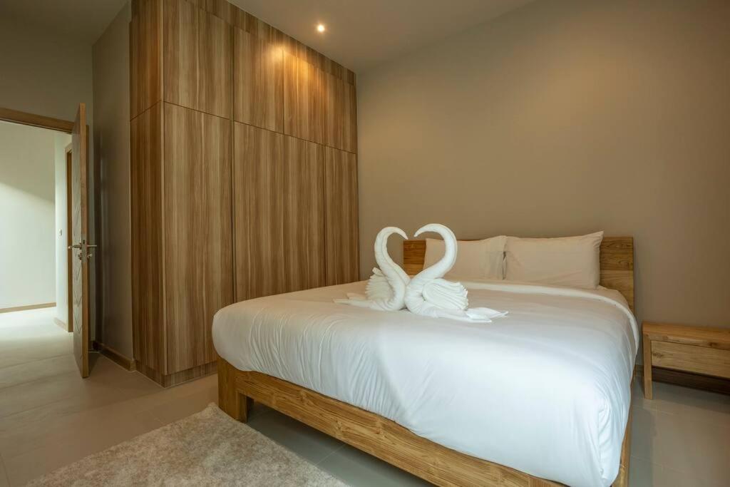 Completed 09-10-2024 Beautiful 4BR V139 في تشالونج: اثنين من البجعات جالسين على سرير في غرفة النوم