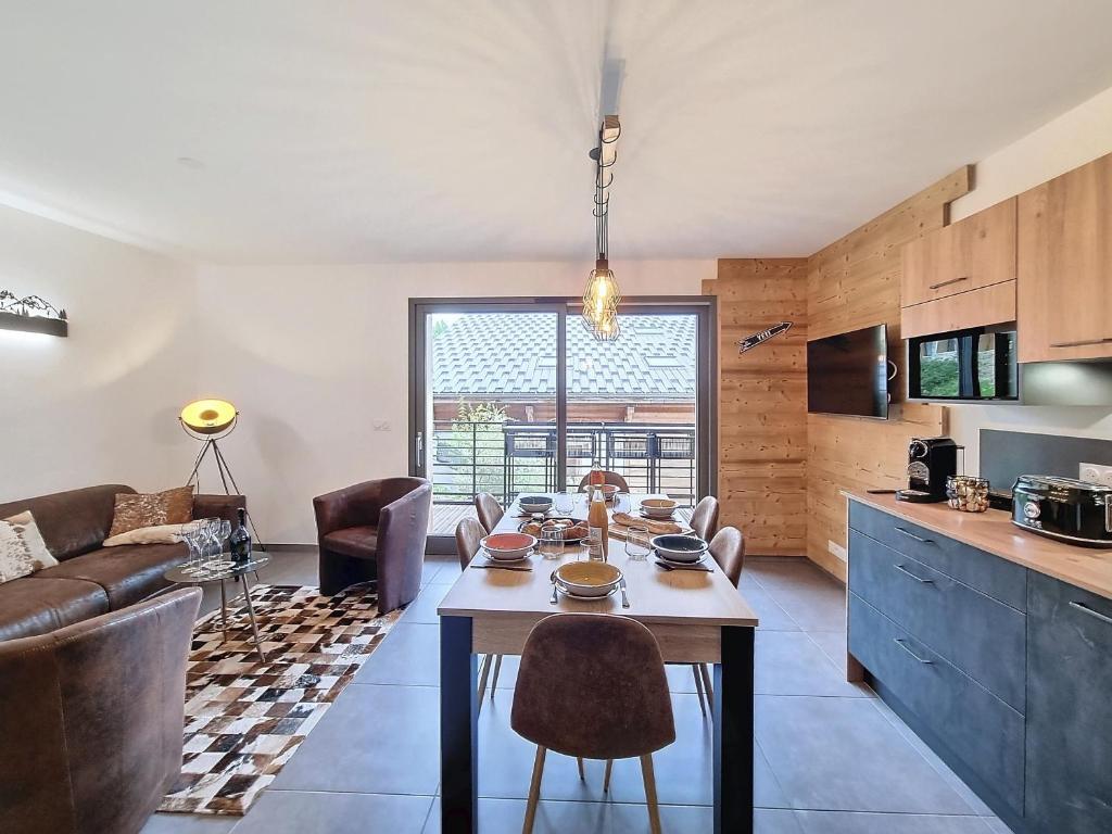 une cuisine et un salon avec une table et des chaises dans l'établissement Cardena- appartement- 8pers- proche centre, aux Gets