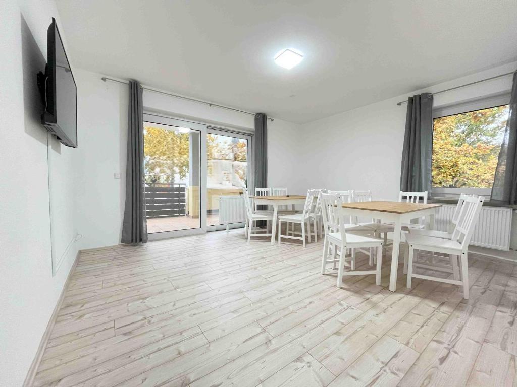 a dining room with a table and chairs and windows at LAP101 - Große Moderne Monteurwohnung Übergangswohnung in Lappersdorf