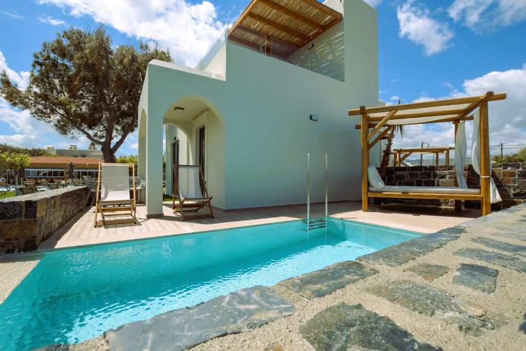 a villa with a swimming pool and a house at Malena Hotel & Suites - Adults Only by Omilos Hotels in Amoudara Herakliou