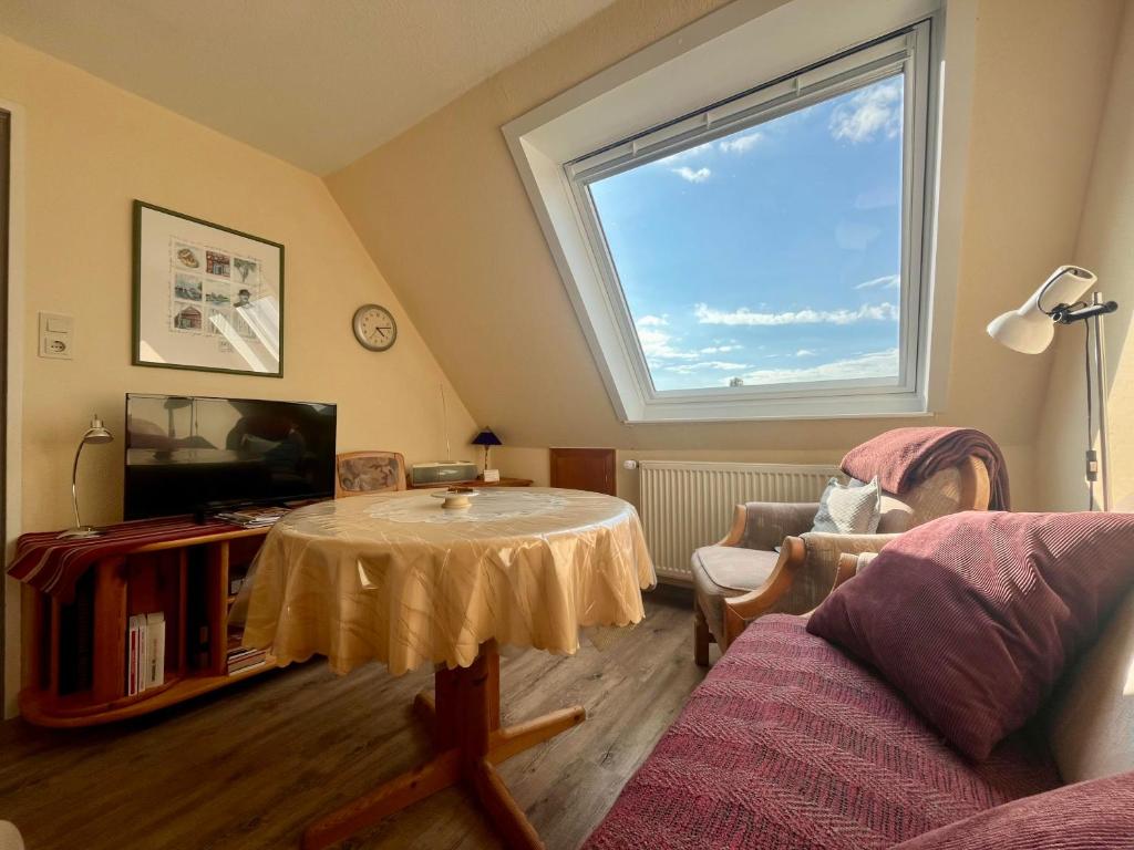 a living room with a table and a window at Ferienwohnung Janssen in Borkum