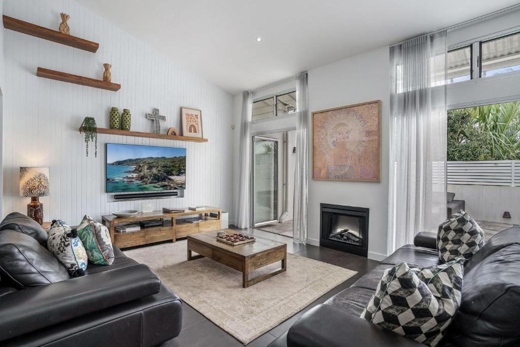 a living room with a couch and a fireplace at Byron Marvel Penthouse - Walk to beach - Sleeps 10 | Winter Escape Deal | Stay Longer & Save | 1 June – 31 August in Byron Bay