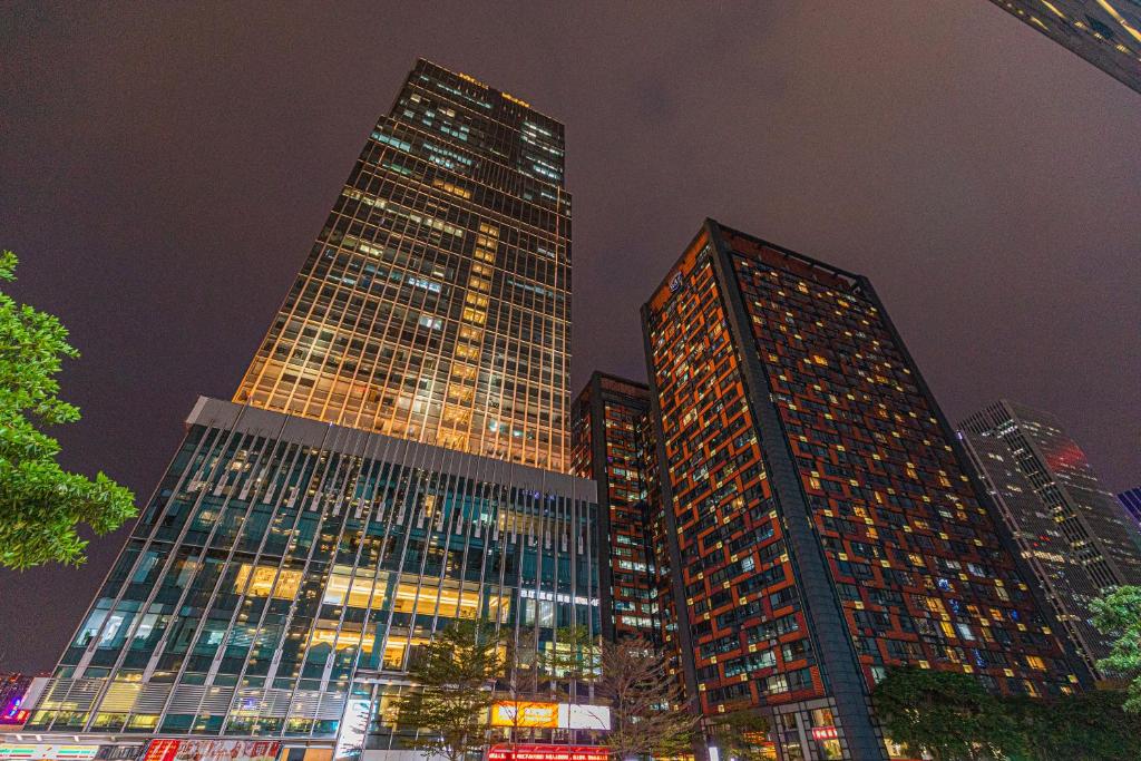 a group of tall buildings in a city at night at Orange International Hotel Guangzhou Zhujiang New Town US Consulate General Guangzhou Branch - Free Shuttle Bus to Canton Fair Complex During Canton Fair Period in Guangzhou