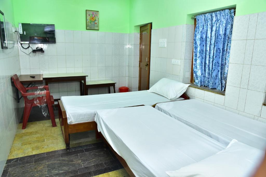Postel nebo postele na pokoji v ubytování Sri Tirumalaa Hotel