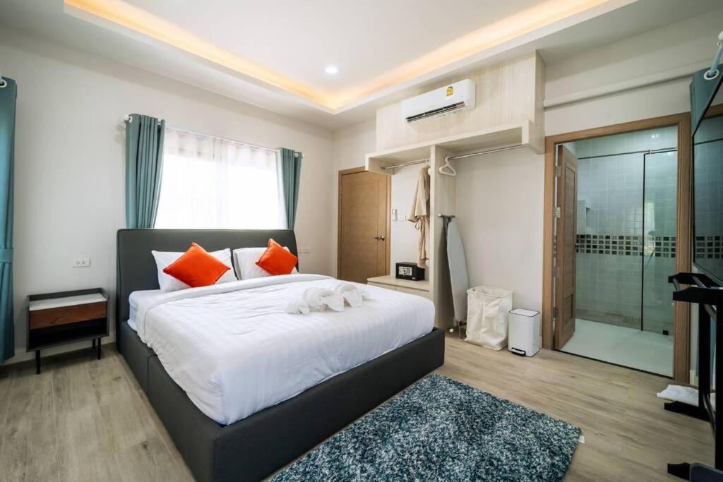 バーン・クロンムアンにあるPool villa Alawan Krabi Klong Muangのオレンジ色の枕が付いた大きなベッドのある寝室