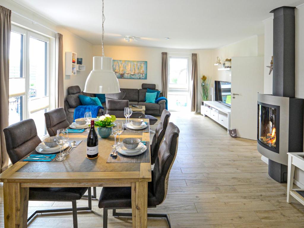 a dining room and living room with a table and a fireplace at Ferienhaus Segelblick LUV in Holnishof