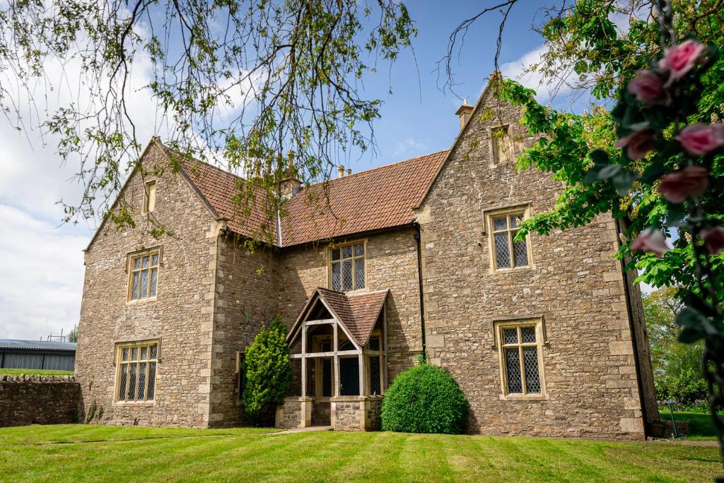 ソーンベリーにあるThornbury Lodgeの緑の芝生の大きな石造りの家