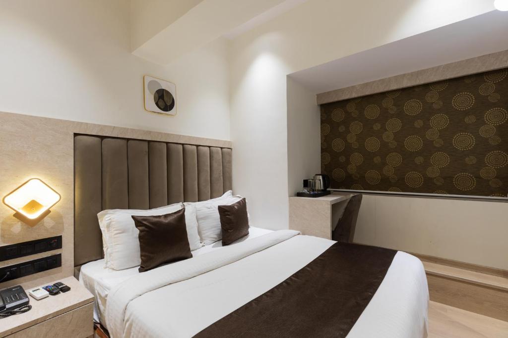 a hotel room with a bed and a large window at Hotel Larmont Luxury in Mumbai