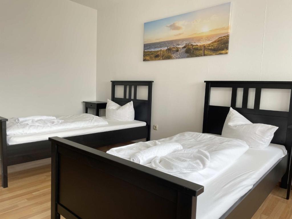 two beds in a room with white sheets at SAD161 - Gut geschnittene Monteurwohnung mit Balkon in Schwandorf in Bayern
