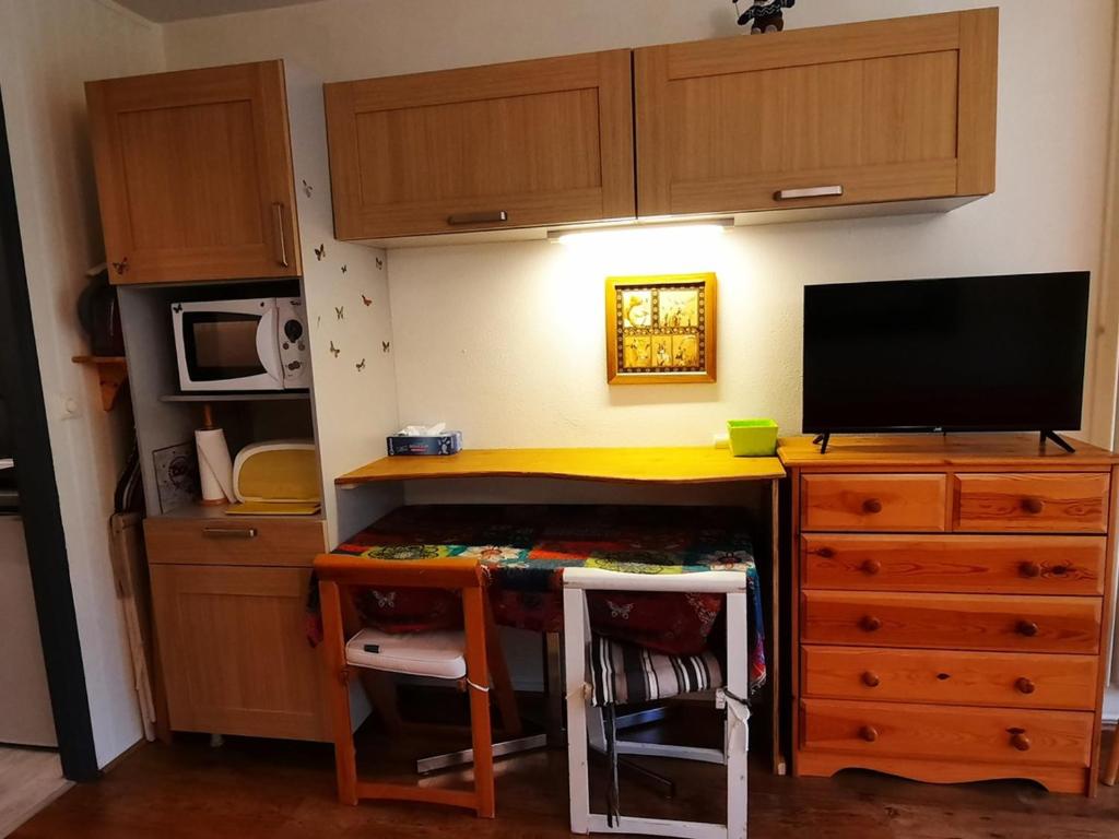 Cette chambre dispose d'un bureau avec une télévision et d'un bureau avec une chaise. dans l'établissement Studio cozy pour 4, au pied des pistes de Villard-de-Lans - FR-1-689-142, à Villard-de-Lans