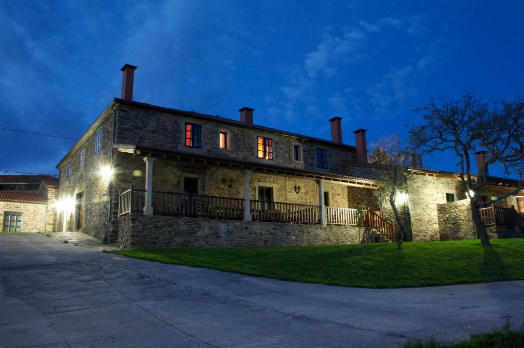 un viejo edificio de piedra con luces encendidas por la noche en Casa Don Benito, en Arnego