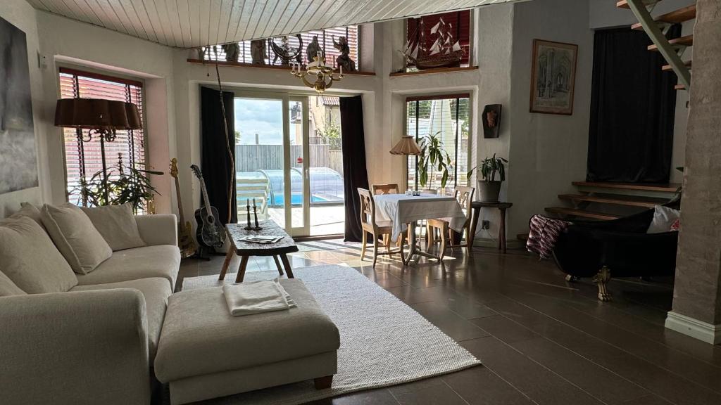 a living room with a couch and a table at Unikt boende i egen del av hus nära stad och strand in Ystad