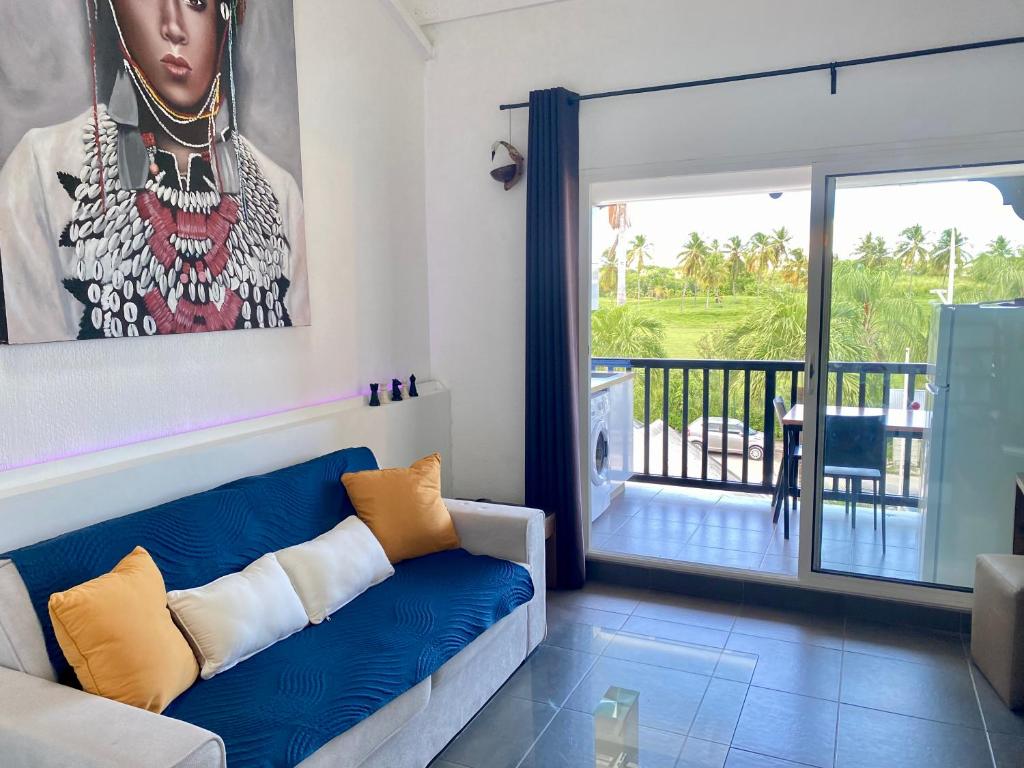 Una sala de estar con un sofá y un balcón. en Duplex du Golfeur, en Saint-François