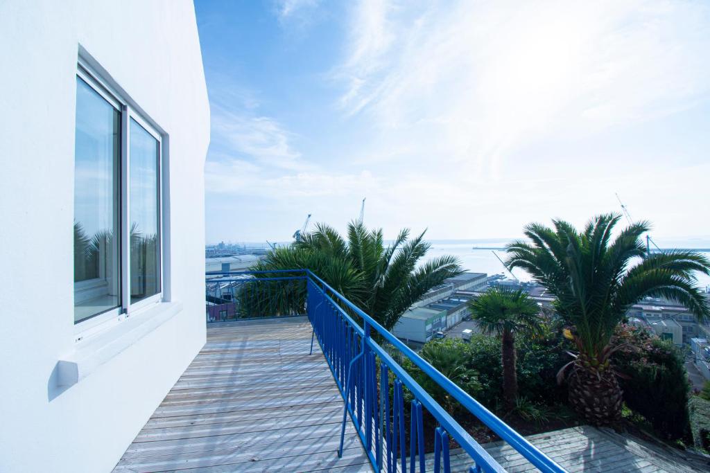 d'un balcon avec une balustrade bleue et des palmiers. dans l'établissement Panorama d'Azur I Vue mer & 13 personnes, à Brest