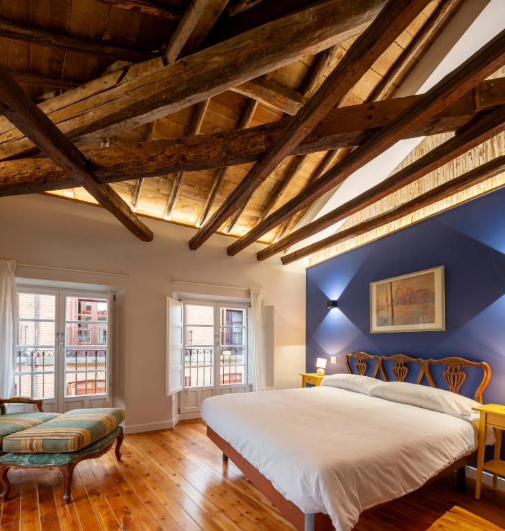 a bedroom with a large bed and blue walls at Apartamento con PARKING- Altior - Catedral Homes in Ávila