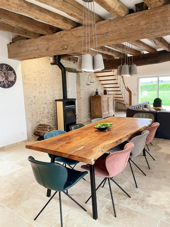 une table et des chaises en bois dans un salon dans l'établissement La Molinière, belle demeure avec séjour cathédrale - La Molinière, beautiful residence with cathedral living room, à Les Montils