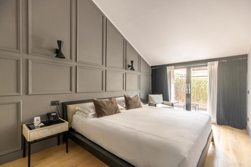 a bedroom with a large white bed and a table at Roma Luxus Hotel in Rome