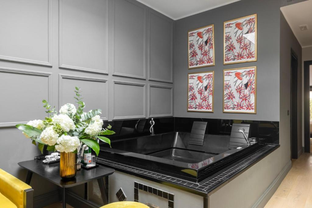 a kitchen with a sink and a table with flowers at Roma Luxus Hotel in Rome