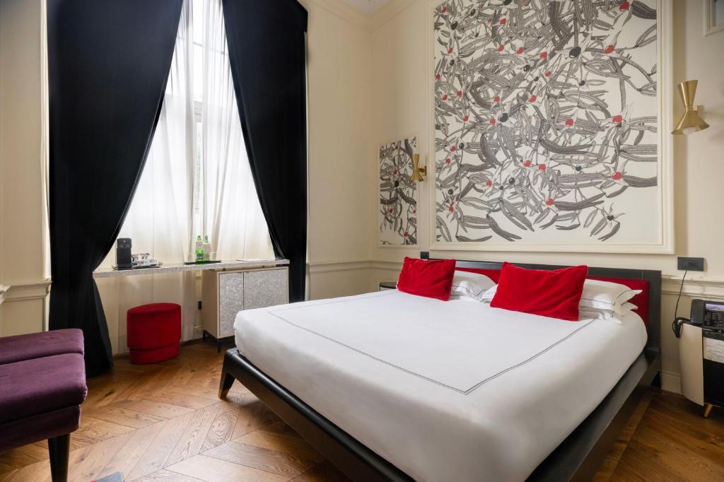 a bedroom with a large bed with red pillows at Roma Luxus Hotel in Rome