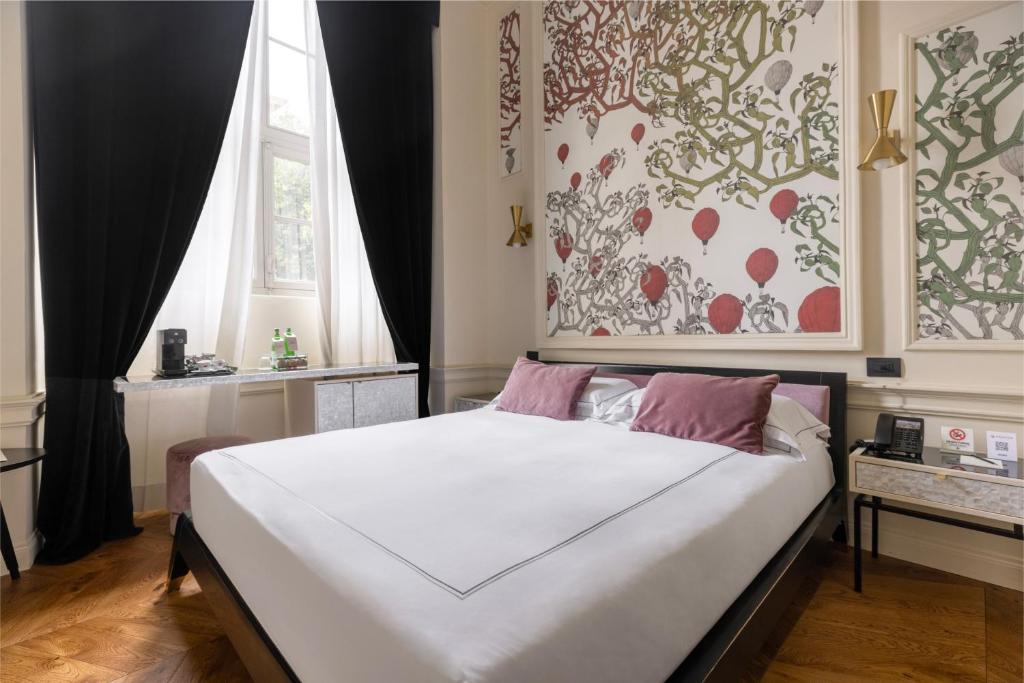 a bedroom with a large white bed with a window at Roma Luxus Hotel in Rome