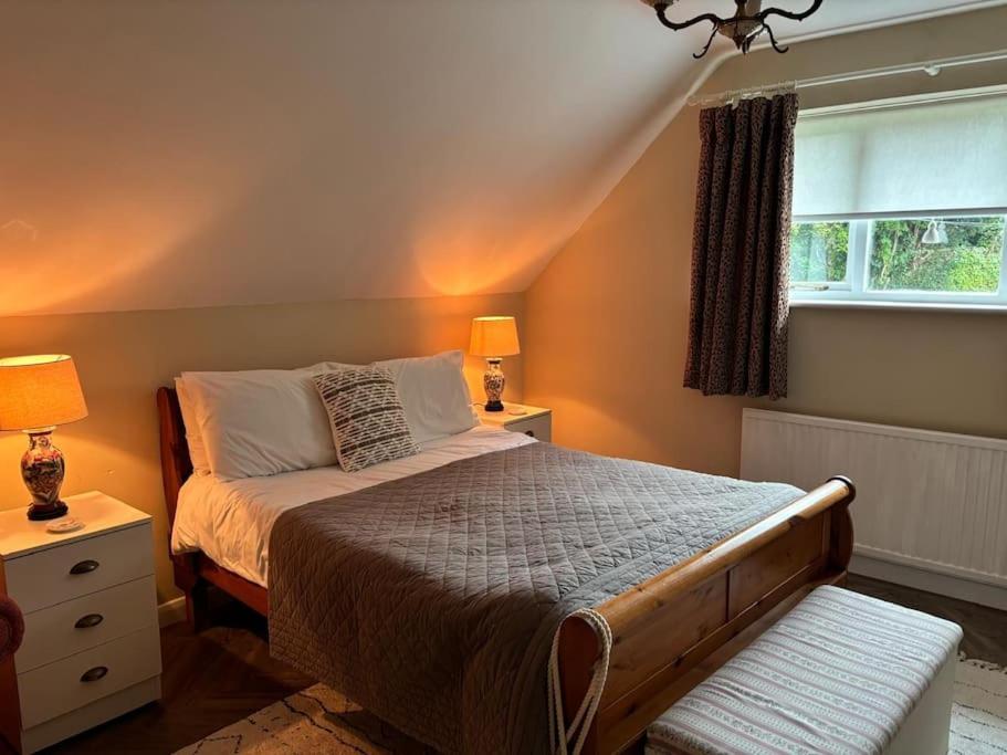 a bedroom with a bed and two lamps and a window at Church View, Poltimore Village - near Exeter in Exeter