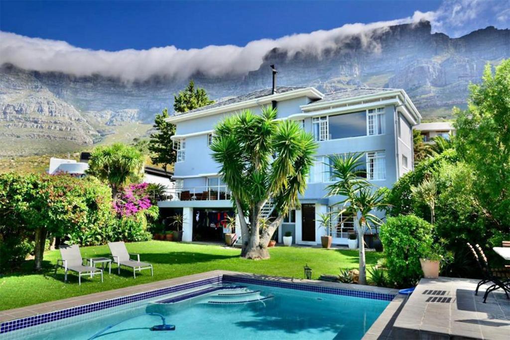 a house with a swimming pool with a view of the mountains at Villa Blue Sky Cape Town in Cape Town