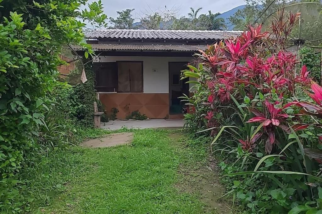 a house with a garden with pink flowers at Casa térrea in Paraty