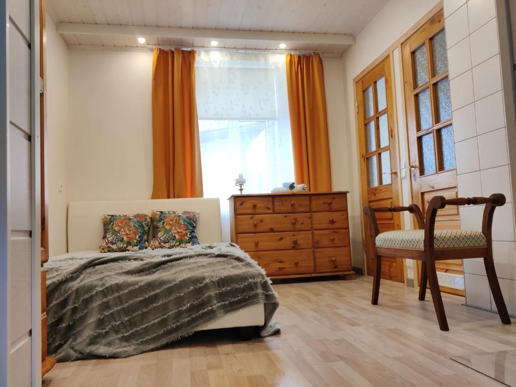 a bedroom with a bed and a dresser and a window at Suure terrassiga korter raudteejaama lähedal in Viljandi