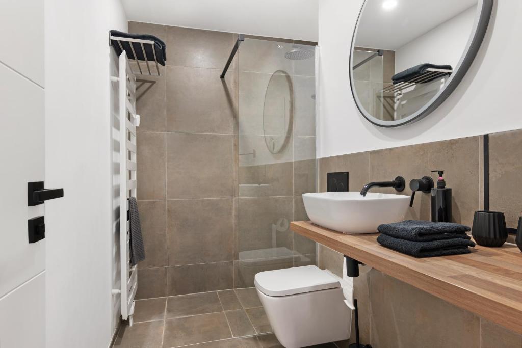 a bathroom with a sink and a toilet and a mirror at Luxus Appartement mit Panoramablick in Sinsheim