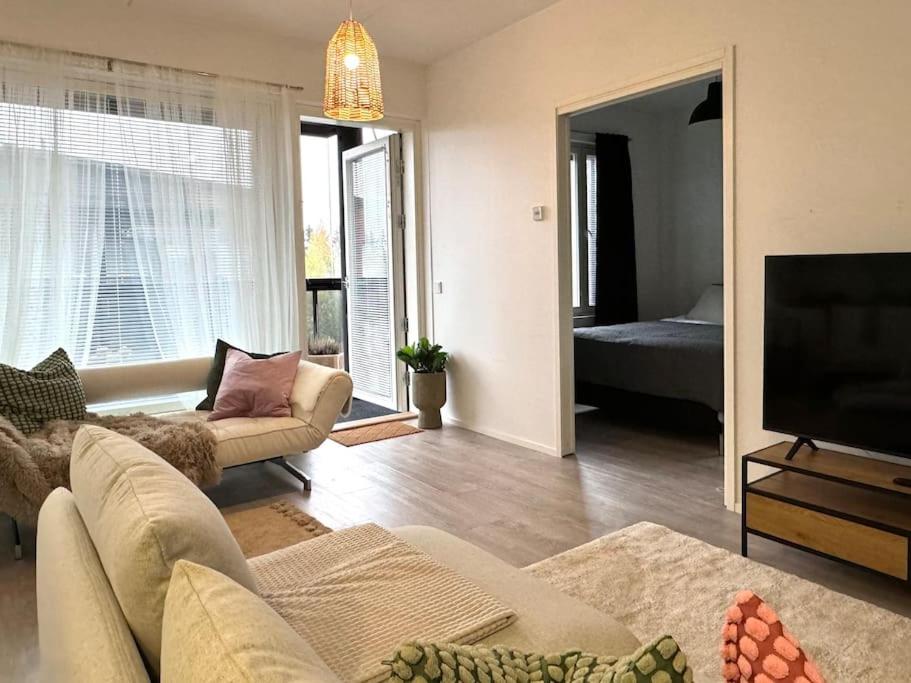 a living room with a couch and a flat screen tv at Moderni kaksio lähellä keskustaa in Seinäjoki