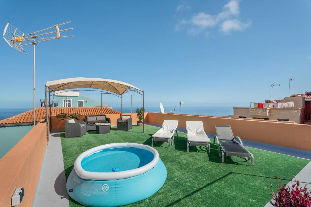 a patio with chairs and a swimming pool on a roof at Casa Con Vista in La Guancha