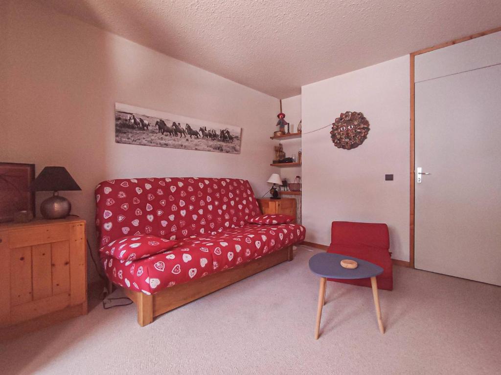 un salon avec un canapé rouge et une table dans l'établissement Grand studio divisible, pied des pistes à Valmorel, proche commerces - FR-1-356-408, à Valmorel