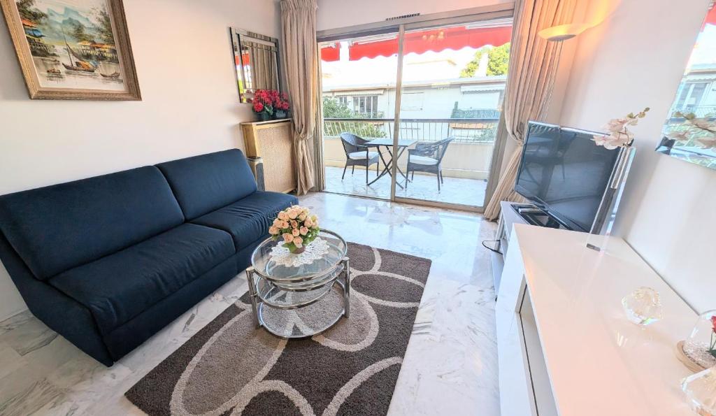 un salon avec un canapé bleu et une table dans l'établissement Ref FLEUR51 by Palmes dProperties, à Cannes