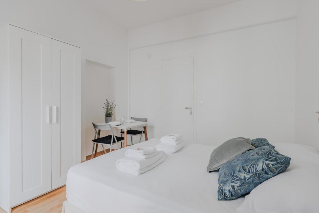 une chambre blanche avec un lit et une table dans l'établissement Joli studio pour 2 personnes - Levallois-Perret, à Levallois-Perret