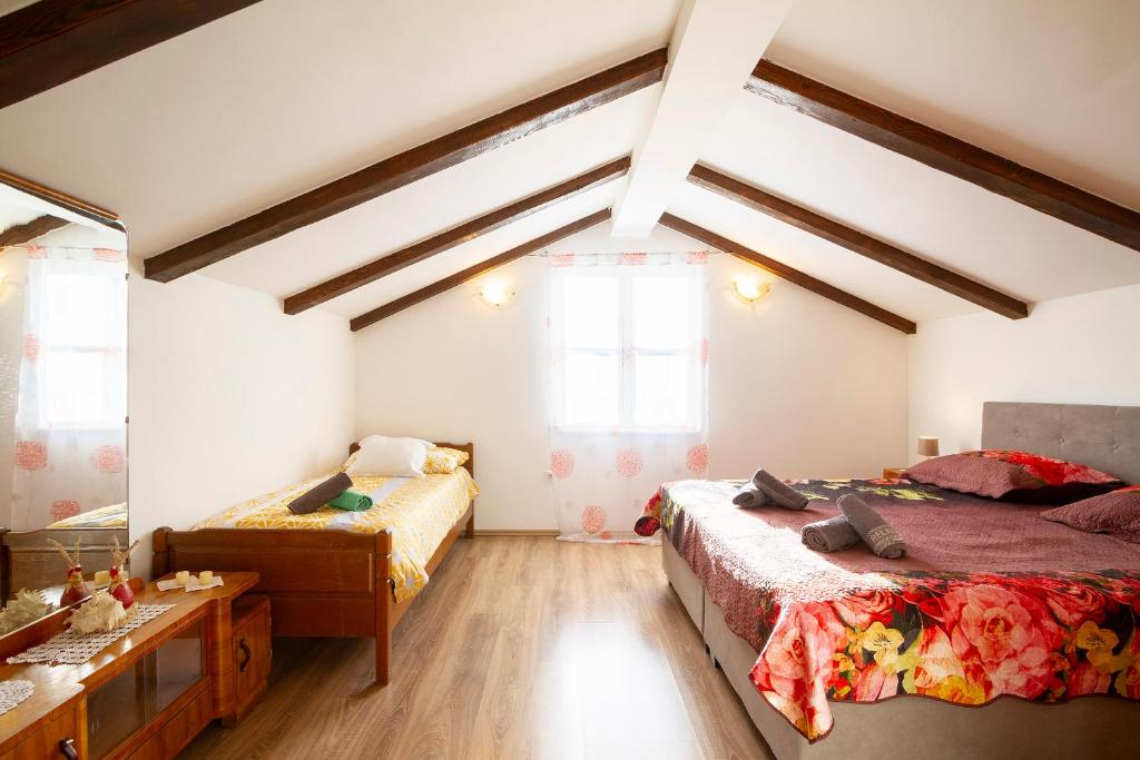 a bedroom with two beds and a table at Woodland Retreat in Donji Zagon