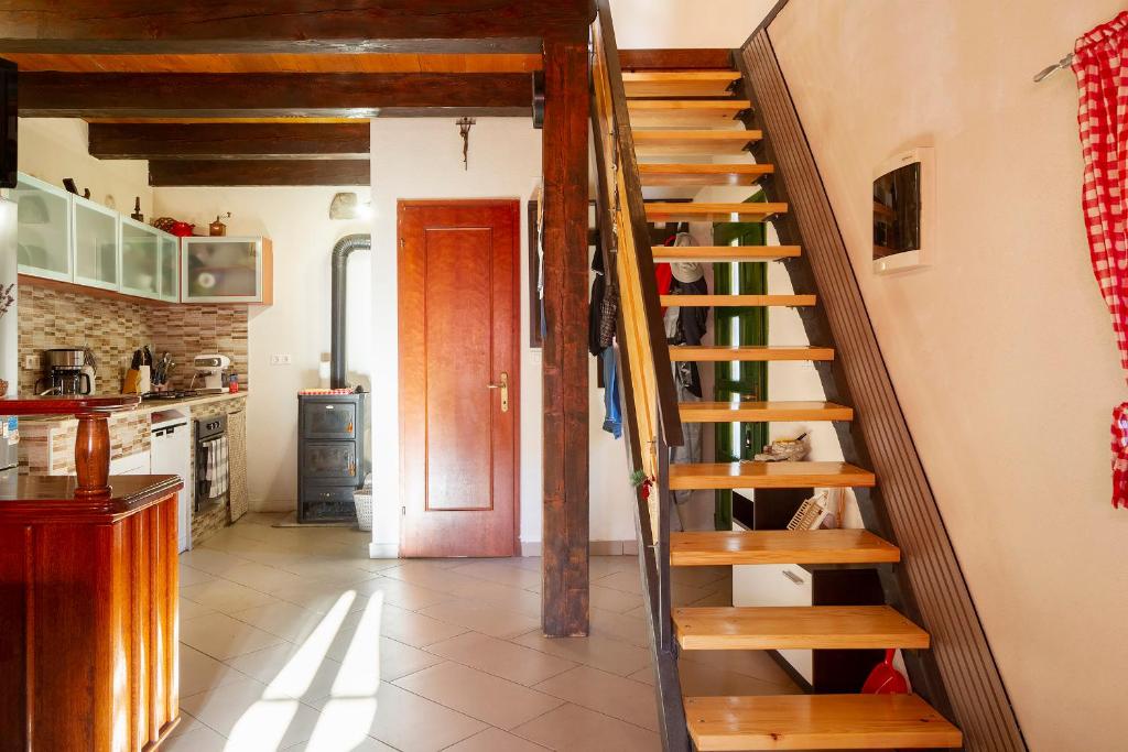 a kitchen with a wooden spiral staircase in a house at Woodland Retreat in Donji Zagon
