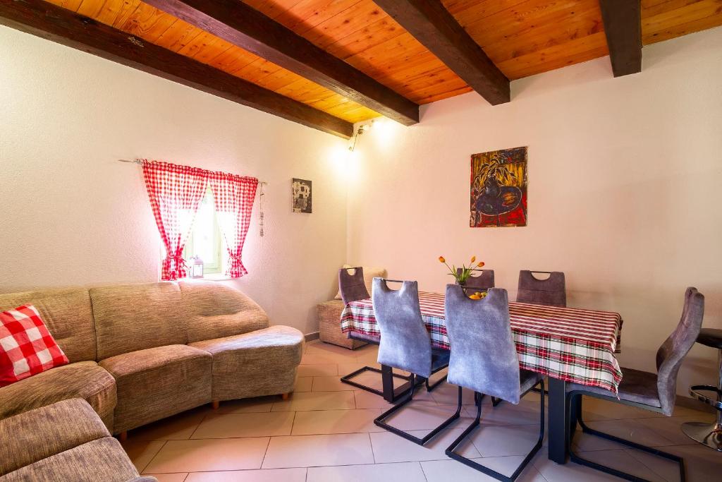 a living room with a couch and a table and chairs at Woodland Retreat in Donji Zagon