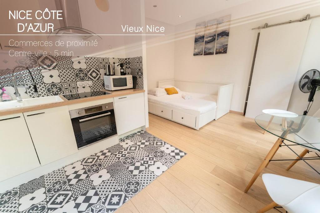 une cuisine avec des armoires blanches et un tapis noir et blanc dans l'établissement Joli studio au cœur de la vieille ville, à Nice